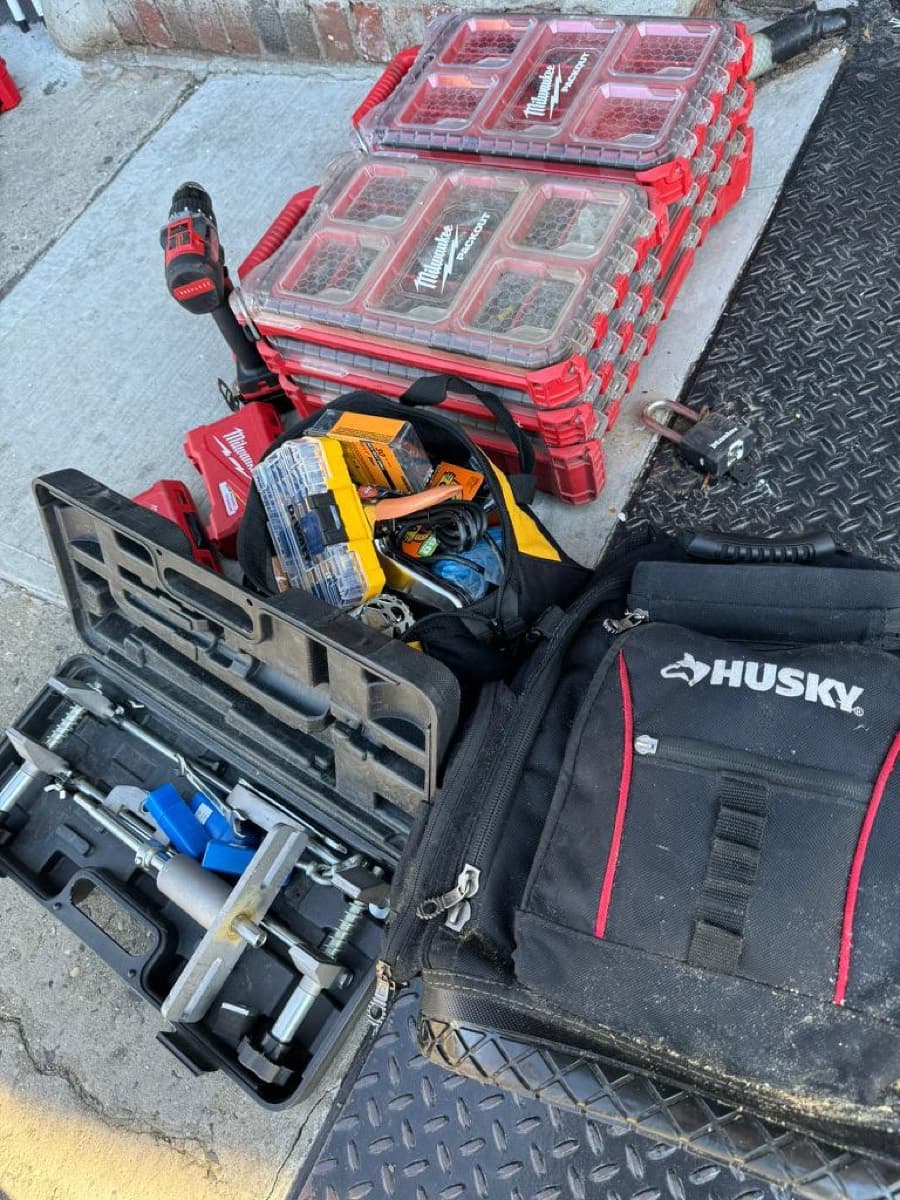 Tool cases and a lock-service kit laid out on the sidewalk