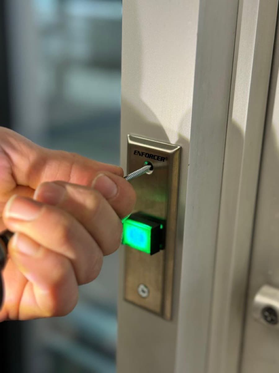 Exit release button with a lit indicator, fitted beside a door